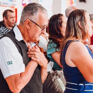 A diverse group of adults in prayer inside a church, expressing spirituality and devotion.