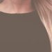 Close-up portrait of a woman with long, flowing blonde hair against a textured background.