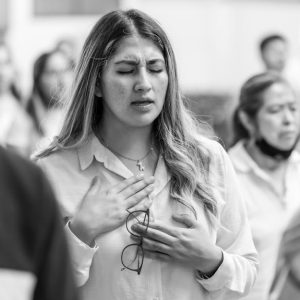A woman in prayer with closed eyes at a gathering in Ciudad de México.