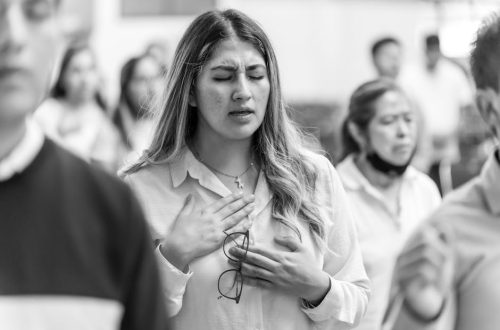 A woman in prayer with closed eyes at a gathering in Ciudad de México.