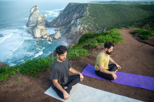 Two men meditating on a scenic cliffside in Portugal. Serenity and nature combined.