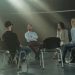 A group therapy session with six adults seated in a circle, discussing support and mental health.