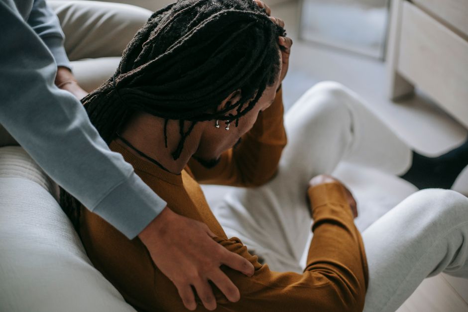 High angle of anonymous young black couple in casual clothes spend time together while calming each other in bedroom in daylight