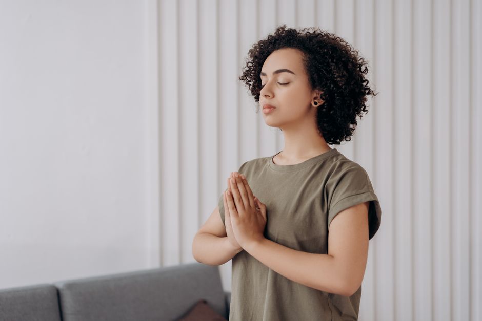 Young woman meditating indoors, practicing mindfulness and relaxation. Peaceful and serene atmosphere.