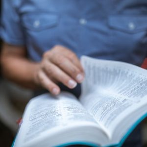 Close-up of an individual reading a Bible, emphasizing devotion and focus.