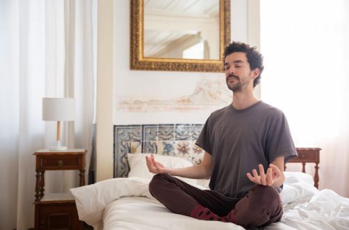 Discover tranquility as a man meditates in a serene bedroom environment, capturing the essence of peace.