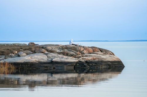 Serene landscape of a rocky shoreline and calm sea at twilight.