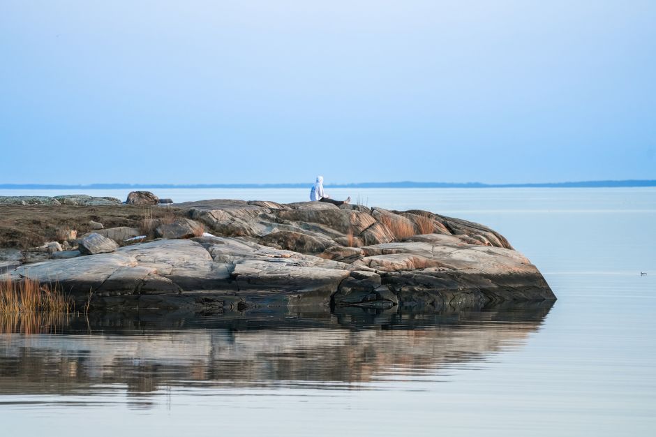 Serene landscape of a rocky shoreline and calm sea at twilight.