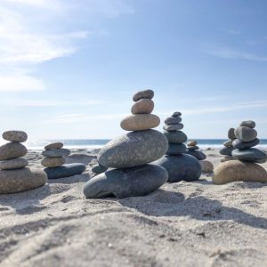 Stone towers on a sunlit beach, capturing tranquility and nature's balance.