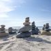 Stone towers on a sunlit beach, capturing tranquility and nature's balance.