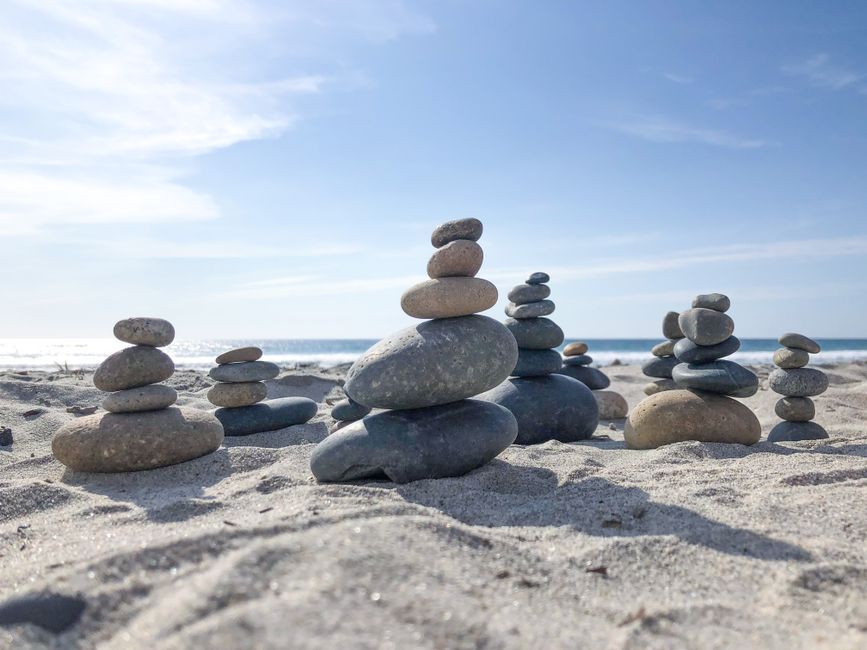 Stone towers on a sunlit beach, capturing tranquility and nature's balance.