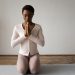 A woman meditating on a yoga mat in a serene indoor setting, emphasizing mindfulness.