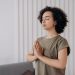 Young woman meditating indoors, practicing mindfulness and relaxation. Peaceful and serene atmosphere.