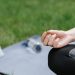 Close-up of a woman meditating outdoors on a mat. Focus on tranquility and mindfulness.