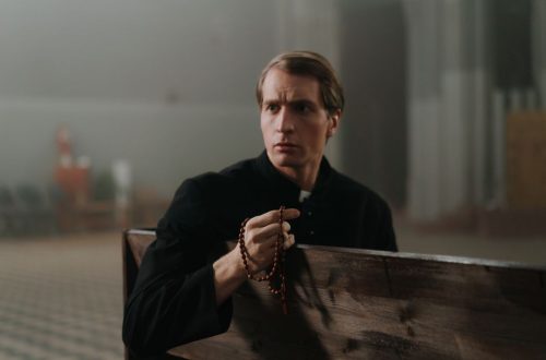 A priest holding rosary beads, seated in a church pew, embodying spirituality and tranquility.