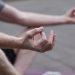 Close-up of hands in a meditation pose outdoors, symbolizing peace and mindfulness.