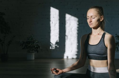 A woman meditates indoors in a serene yoga session, embracing mindfulness and tranquility.