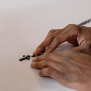 A close-up of hands holding a rosary, symbolizing faith and prayerfulness in a spiritual context.