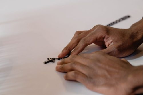 A close-up of hands holding a rosary, symbolizing faith and prayerfulness in a spiritual context.