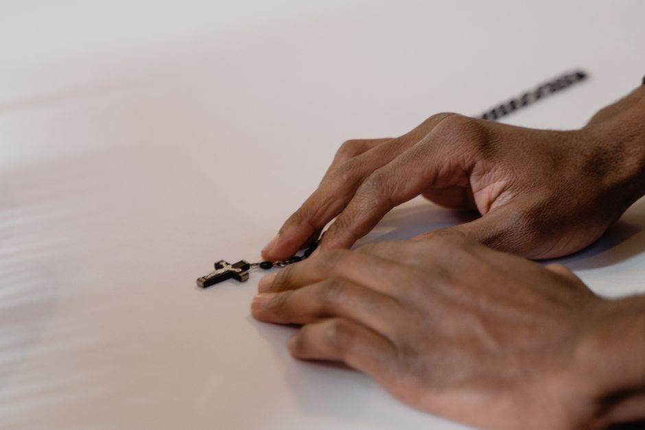 A close-up of hands holding a rosary, symbolizing faith and prayerfulness in a spiritual context.