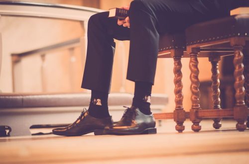 Elegant shoes and socks in a serene church setting capture a moment of reflection.