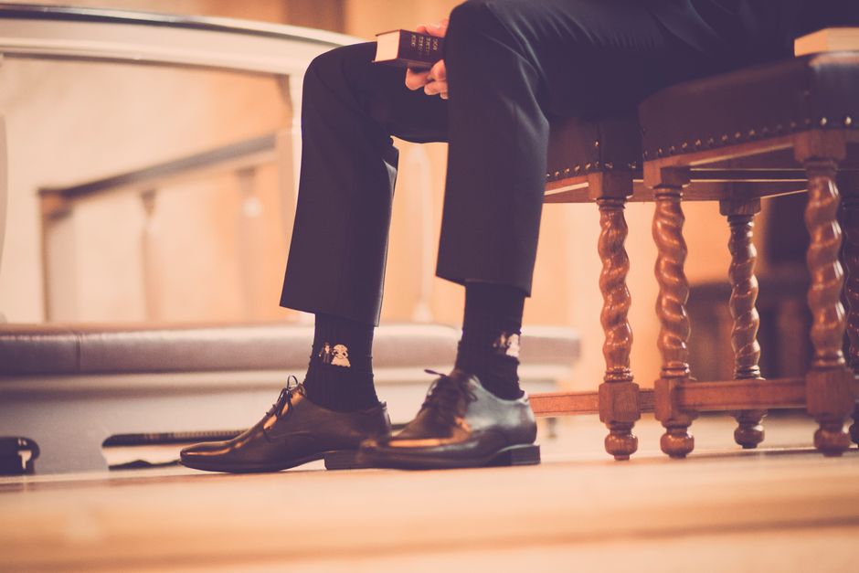 Elegant shoes and socks in a serene church setting capture a moment of reflection.