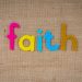 Brightly colored text spelling 'faith' on a textured burlap material, conveying spirituality and belief.