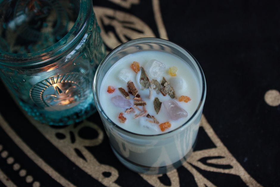 Top-down view of an aromatic candle with crystals in a decorative setting. Ideal for relaxation themes.