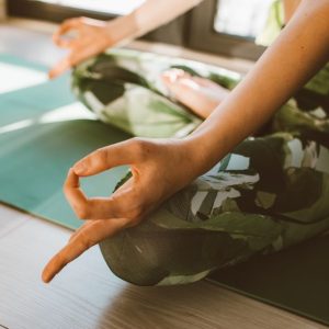 Serene close-up of woman practicing yoga on a mat indoors in natural light.