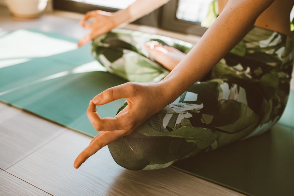 Serene close-up of woman practicing yoga on a mat indoors in natural light.
