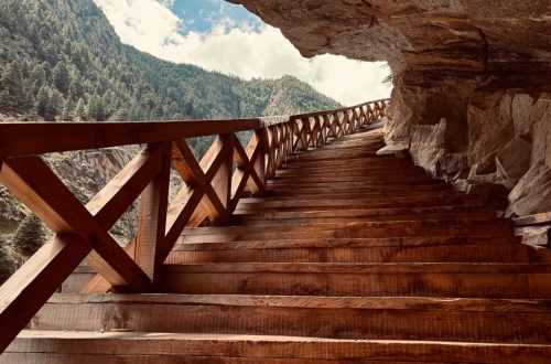Scenic view of wooden stairs leading through a mountain passage in Bhatwari, showcasing nature's beauty.