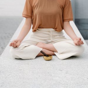 A person meditating outdoors with a singing bowl, embracing serenity and mindfulness.