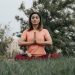 Woman practicing yoga and meditation in park. Enhancing mindfulness and relaxation outdoors.