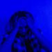 Portrait of a distressed person under dramatic blue lighting, expressing mental anguish.