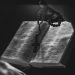 A black and white image of an open Bible with rosary beads, symbolizing faith and spirituality.