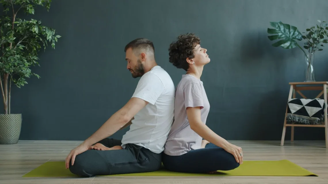 Casal meditando de costas um para o outro em um espaço de meditação acolhedor e tranquilo