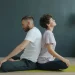 Casal meditando de costas um para o outro em um espaço de meditação acolhedor e tranquilo