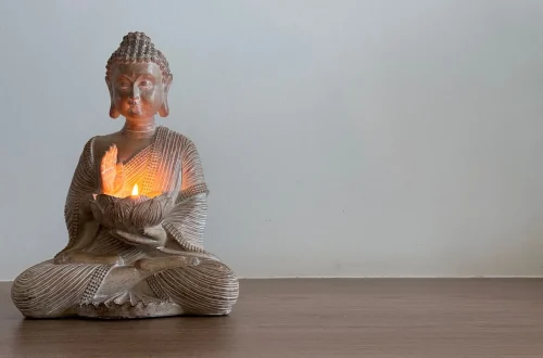 Estátua de Buda em um ambiente sereno com velas acesas, perfeito para criar um espaço de meditação