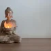 Estátua de Buda em um ambiente sereno com velas acesas, perfeito para criar um espaço de meditação