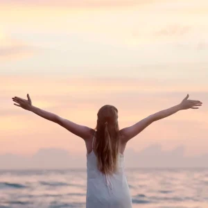 Mulher desfrutando de um pôr do sol sereno na praia de Unawatuna, simbolizando a gratidão na meditação