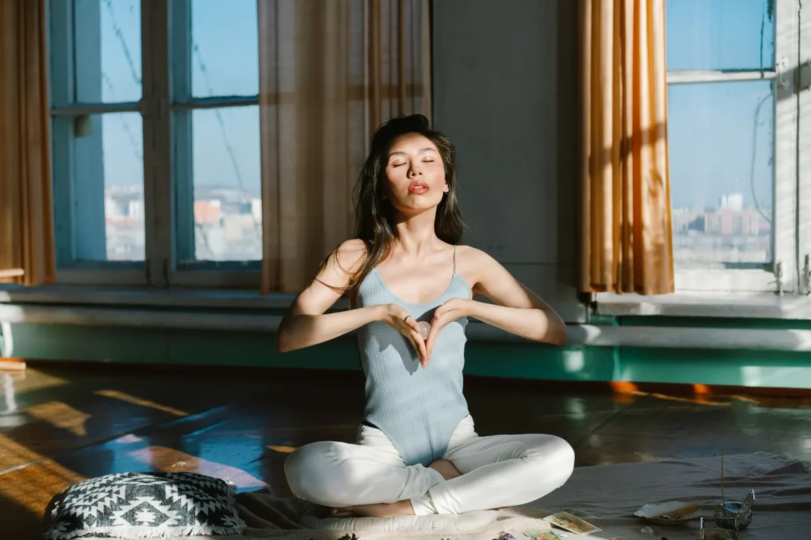 Mulher étnica em posição de meditação com cristais, simbolizando a gratidão na meditação e conexão espiritual