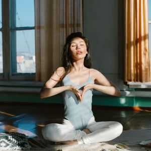 Mulher étnica em posição de meditação com cristais, simbolizando a gratidão na meditação e conexão espiritual