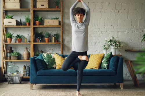 Mulher praticando yoga em sala de estar moderna com plantas e decoração aconchegante, ideal para um espaço de meditação