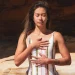 Mulher relaxa ao ar livre com respiração profunda, em estado meditativo, refletindo sobre gratidão na meditação