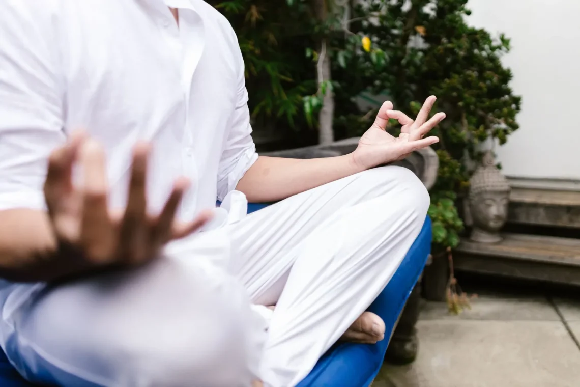 Pessoa vestindo branco meditando ao ar livre em um ambiente sereno, simbolizando a gratidão na meditação